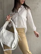 Camisa blanca de manga larga con bordado floral en las mangas.