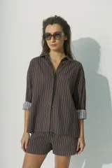 Camisa marrón a rayas verticales negras y rojas, de corte relaxed, con cuello clásico y botones al tono.