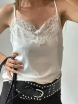 Musculosa blanca de breteles finos con escote en V y detalle de encaje en el busto.