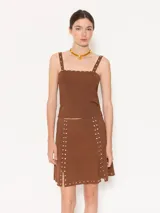 Pollera marrón tejida con calce al cuerpo, de largo arriba de las rodillas y detalle de tachas plateadas.