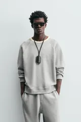 Sudadera gris de tejido compacto con mezcla de algodón y viscosa, corte relaxed fit, cuello redondo con rib combinado a contraste, manga larga y acabados en rib.
