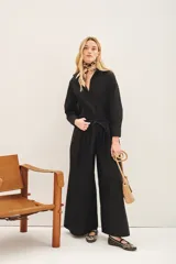 Mono negro con corte palazzo, mangas largas y lazo en la cintura.
