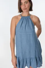 Vestido corto color beige, con escote halter, tirantes finos y falda con volados.