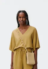 Blusa color crema con escote en V y mangas cortas amplias.