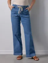 Pantalón jean de tiro alto, corte wide leg, color celeste, con bolsillos frontales y cordón ajustable en la cintura.