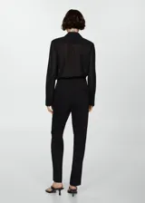 Pantalón de vestir azul marino, de corte recto, con bolsillos laterales y traseros. Se ajusta a la cintura con cinturón de cuero marrón.
