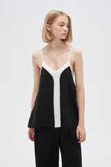 Musculosa de poliéster con breteles finos, diseño color block, corte holgado, escote en V y elástico en el ruedo.