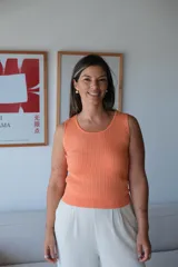 Musculosa de tejido de punto color coral, con cuello redondo y diseño de ochos trenzados verticales.
