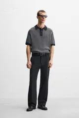 Polo de punto de algodón a rayas verticales en tonos azul marino y gris. Tiene cuello clásico, tapeta con botones y corte recto.
