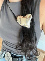 Pinza de pelo dorada con forma de corazón.