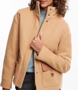Saco color beige en polyvelour, con cuello alto, mangas largas, sisas desplazadas, cierre delantero y bolsillos con detalle en PU.