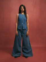 Pantalón de jean celeste de corte acampanado con costuras verticales en el frente.