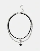 Set de dos collares plateados, uno de cadena gruesa y otro de cuentas negras, ambos con dije de estrella.