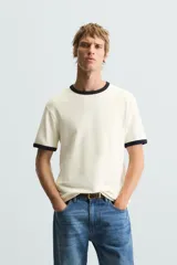 Camiseta azul marino de corte regular, con cuello redondo y mangas cortas. Presenta ribete blanco en cuello y mangas.