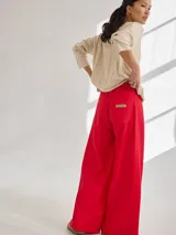 Pantalón negro de pierna ancha con tiro medio alto y pretina elastizada en la espalda. Presenta bolsillos plaque en delantera y espalda.