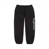 Pantalón de jogging negro de algodón con el logo de Supreme en tipografía Old English a lo largo de la pierna derecha.