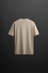 Camiseta relaxed fit color beige confeccionada en tejido con mezcla de algodón, cuello redondo, manga corta y logo estampado en el bajo. Zara Athleticz.