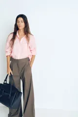 Camisa rosa de lino liviano, de corte recto, con cuello clásico, botones frontales, manga larga con puños abotonados, canesú en la espalda, bolsillo de parche en el pecho y bajo redondeado.
