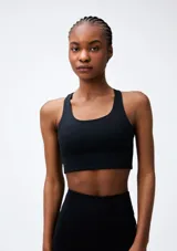 Top deportivo negro con breteles anchos y espalda deportiva.