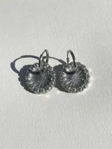 Par de aros colgantes plateados con dije circular de resina y strass, con arito de acero quirúrgico.
