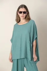 Blusa italiana color verde militar, de lino y algodón, con calado en los costados y espalda, calce holgado y dos bolsillos delanteros.