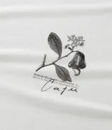 Remera blanca de manga corta con cuello redondo y un pequeño estampado botánico en el lado izquierdo del pecho, que parece ser una ilustración de una planta de café.