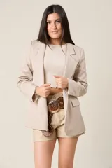 Blazer negro de corte sastre, con solapas de muesca, cierre frontal con un botón y bolsillos delanteros con solapa.