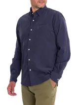 Camisa de hombre de manga larga, color azul marino, confeccionada en cotelé de algodón orgánico. Tiene cuello camisero, cierre con botones y bolsillo en el pecho.