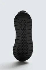 Zapatilla deportiva negra con detalles en piel y acabado serraje.