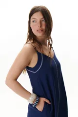 Vestido largo color crudo con breteles finos y costuras a la vista en color azul.