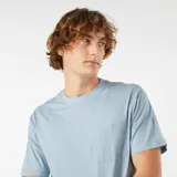 Remera celeste de corte recto, manga corta y cuello redondo. Tiene un bolsillo pequeño en el pecho.