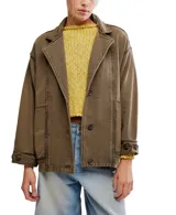 Chaqueta estilo blazer de algodón color marrón oliva, con efecto desgastado y costuras marcadas. Presenta solapas anchas, cierre frontal de dos botones y puños anchos ajustables con botón.