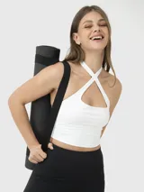 Top deportivo blanco con espalda descubierta y tiras cruzadas en el frente.
