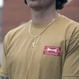 Remera color marrón claro con logo de Etnies y Independent en el pecho.