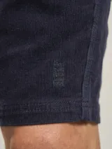 Bermuda de pana azul marino con cintura elástica y cordón ajustable.