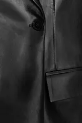 Blazer entallada negra de efecto piel, con cuello solapa y manga larga. Tiene bolsillos de plastrón en el delantero, costuras marcadas y forro interior combinado a tono. El cierre es frontal con botón interior y exterior.
