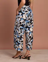 Pantalón capri estampado con flores en tonos celeste, blanco y negro. Tiene pretina elastizada en la parte trasera y bolsillos delanteros.