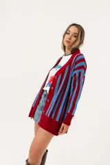 Cárdigan tejido a rayas rojas y celestes, de corte oversize y escote en V.
