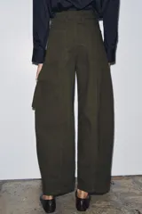Pantalón cargo de tiro medio color verde militar, confeccionado en algodón. Presenta bolsillos delanteros y bolsillos de plastrón con solapa en las piernas.