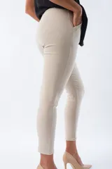 Pantalón color beige de corte Aline, con cintura plisada, bolsillos delanteros y lazo con estampado animal print.