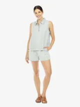 Musculosa de denim celeste, con cuello polo, escote en V con botones, de fit amplio y terminación desflecada en el bajo.