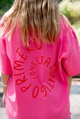 Remerón oversize color fucsia con estampado de dos manos formando un corazón en el pecho y la frase "conecta contigo primero".