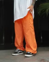 Pantalón naranja de corte holgado con bolsillos laterales, cintura elástica ajustable y tela suave.