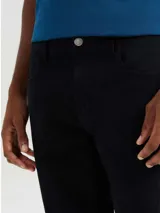 Pantalón negro de corte recto, con tiro medio y bolsillos delanteros y traseros.
