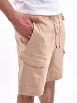 Bermuda color beige, de corte recto, con bolsillos cargo laterales y cintura elastizada con cordón ajustable.