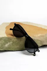 Lentes de sol negros con marco aviador y lentes oscuros.