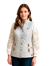 Chaleco capitoneado color celeste con detalles en cuero marrón, cuello alto y cierre con botones a presión.