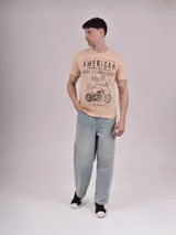 Remera beige de manga corta con cuello redondo y estampado frontal con texto "American" y dibujo de una moto.