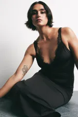 Vestido midi negro de tirantes con escote en pico y detalle de encaje en el escote.