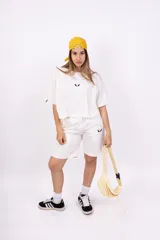 Remera blanca de corte holgado con logo pequeño bordado en negro en el pecho.